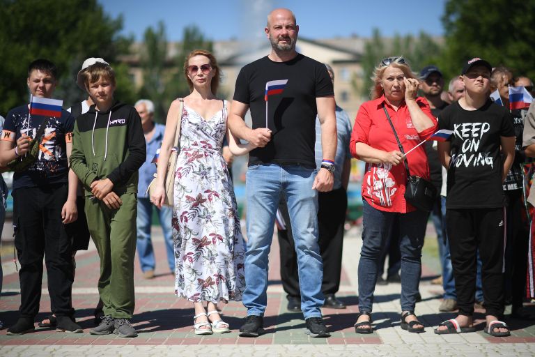 Горожане во время поднятия большого российского флага в честь празднования Дня России на главной площади Мелитополя Горожане во время поднятия большого российского флага в честь празднования Дня России на главной площади Мелитополя