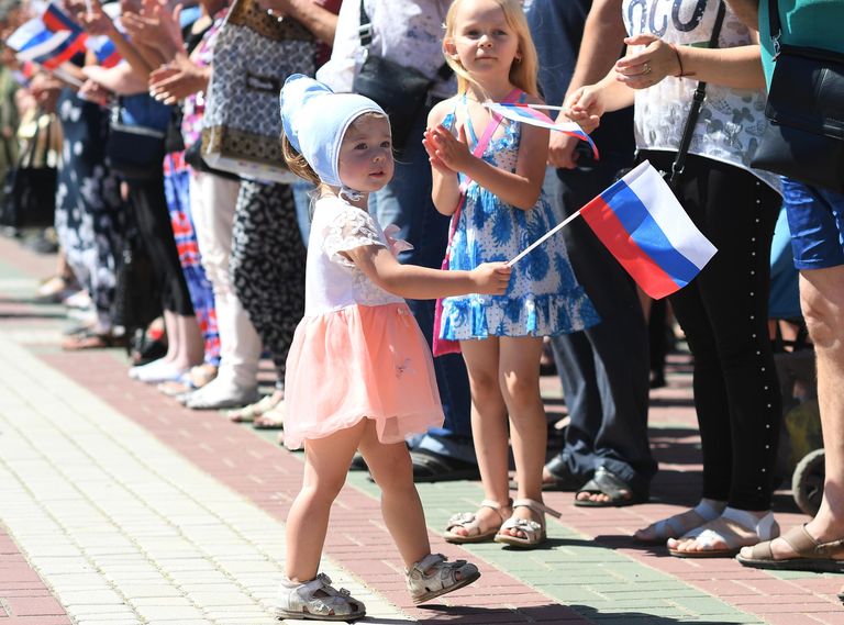 Девочка с российским триколором во время поднятия большого российского флага в честь празднования Дня России на главной площади Мелитополя Девочка с российским триколором во время поднятия большого российского флага в честь празднования Дня России на главной площади Мелитополя