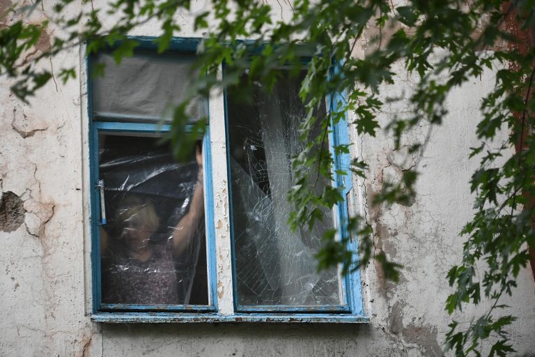 Женщина затягивает полиэтиленовой пленкой окно, разбитое в результате обстрелов ВСУ Донецка. Женщина затягивает полиэтиленовой пленкой окно, разбитое в результате обстрелов ВСУ Донецка.