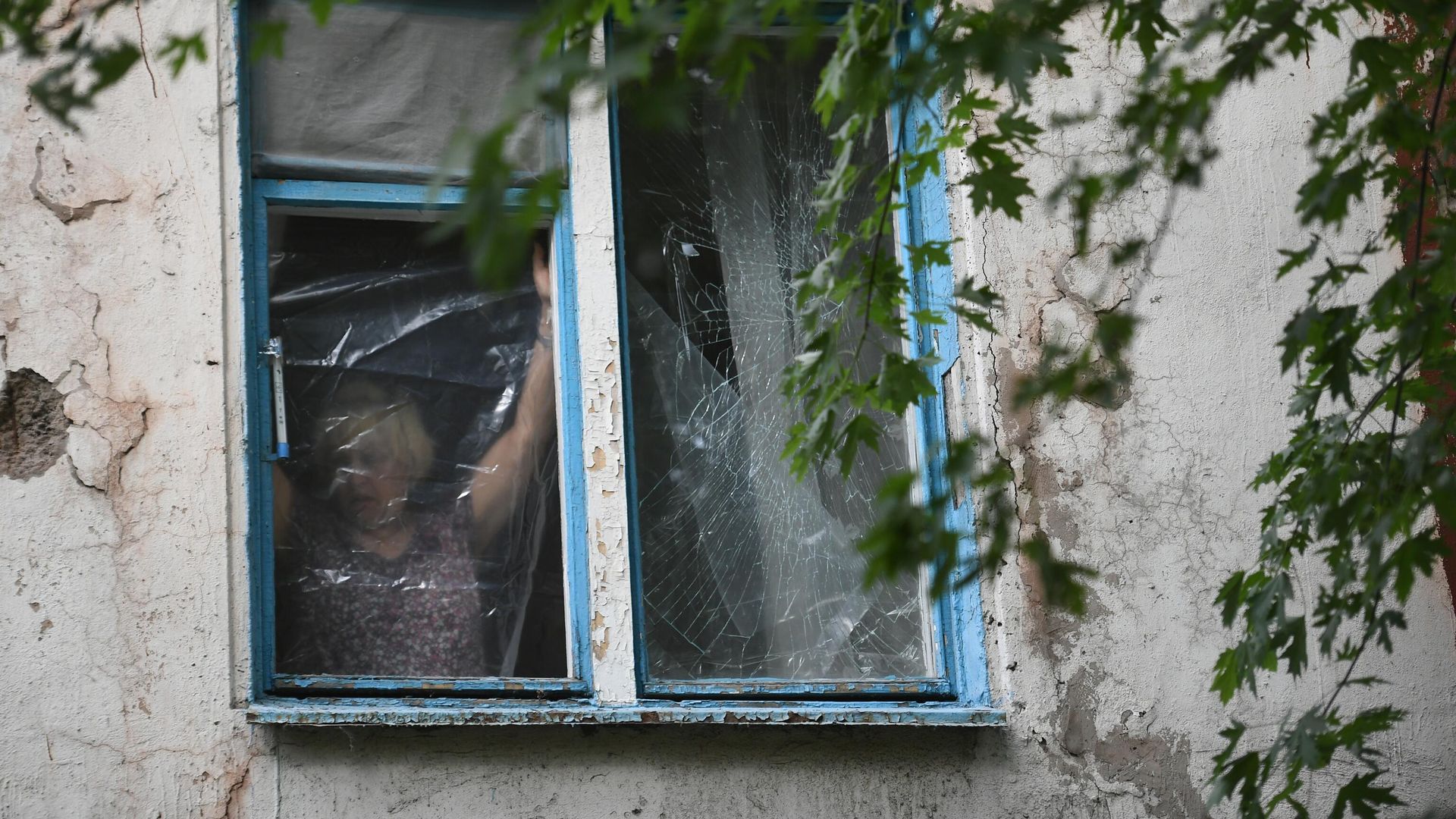 Женщина затягивает полиэтиленовой пленкой окно Женщина затягивает полиэтиленовой пленкой окно - РИА Новости, 1920, 06.10.2022