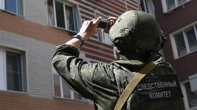 Сотрудник Следственного комитета фиксирует последствия попадания снаряда ВСУ
