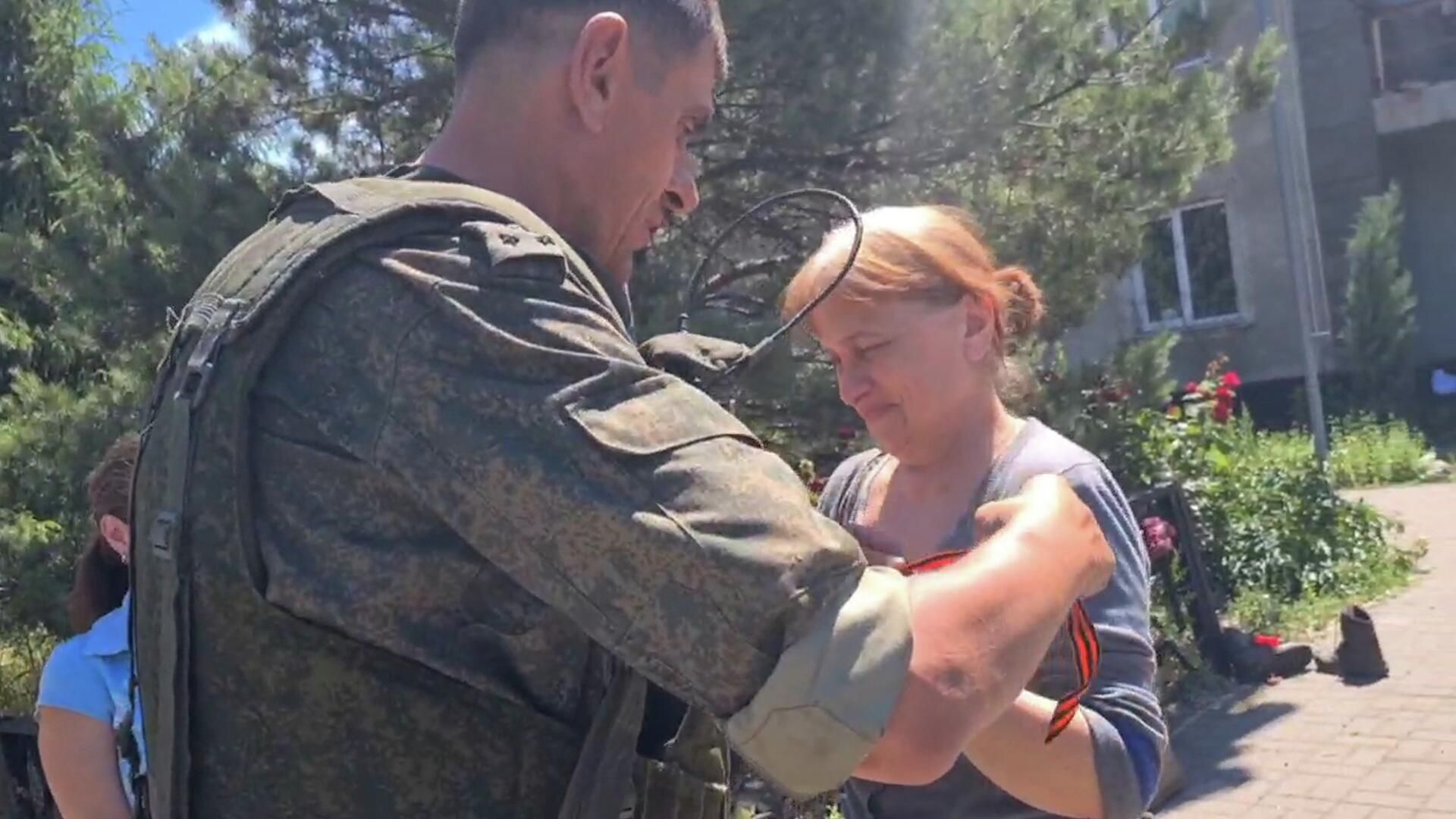 Бойцы ЛНР дарят жителям освобожденных городов Донбасса георгиевские ленты Бойцы ЛНР дарят жителям освобожденных городов Донбасса георгиевские ленты - РИА Новости, 1920, 25.06.2022