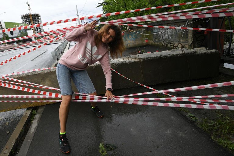 Девушка пересекает ограждение на автомобильном мосту через реку Салгир в Симферополе, на котором, предположительно, из-за подъема воды образовался провал Девушка пересекает ограждение на автомобильном мосту через реку Салгир в Симферополе, на котором, предположительно, из-за подъема воды образовался провал