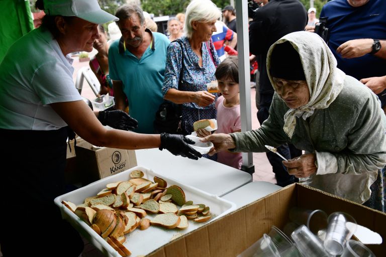 Местная жительница стоит в очереди к полевой кухне, организованной Министерством обороны РФ, на одной из улиц Мариуполя