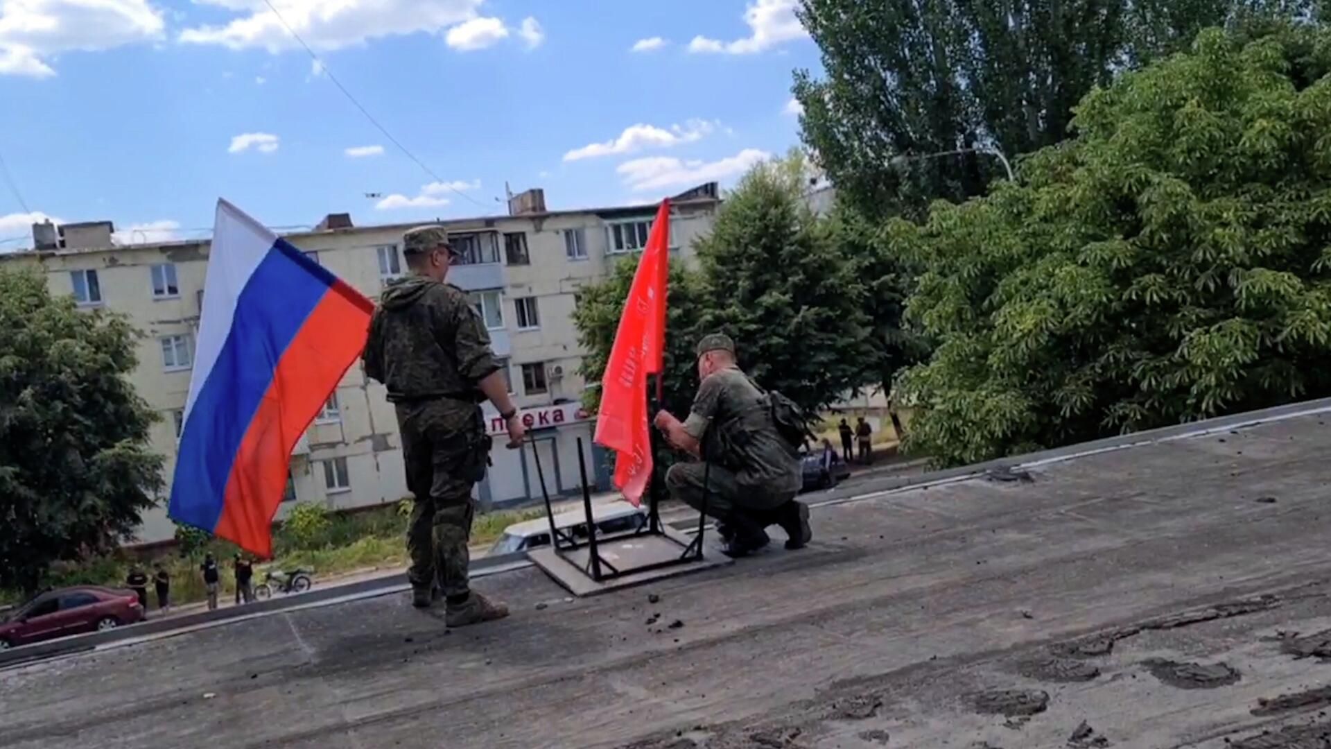 Жители Лисичанска поднимают Знамена Победы и российские триколоры Жители Лисичанска поднимают Знамена Победы и российские триколоры - РИА Новости, 1920, 03.07.2022