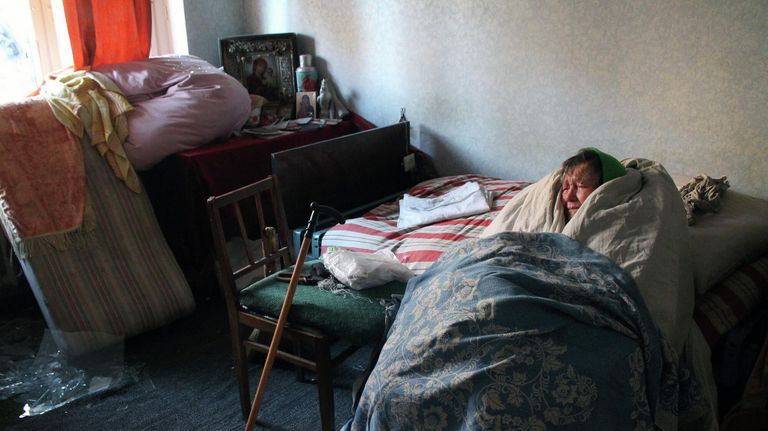 Жительница дома, поврежденного в результате обстрелов, в Киевском районе Донецка. Жительница дома, поврежденного в результате обстрелов, в Киевском районе Донецка.