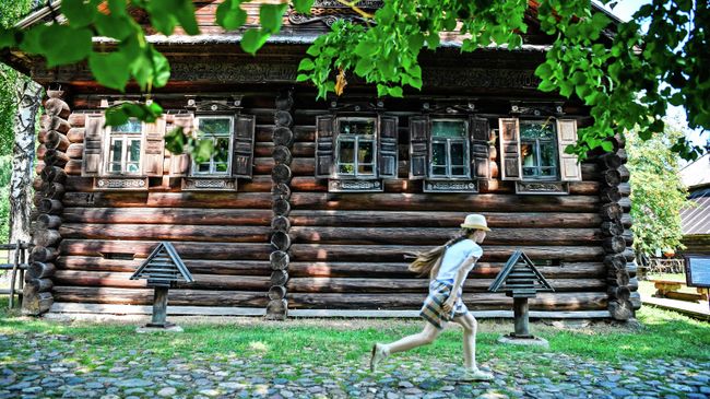 Девочка гуляет на территории музея деревянного зодчества Костромская слобода в Костроме Девочка гуляет на территории музея деревянного зодчества Костромская слобода в Костроме