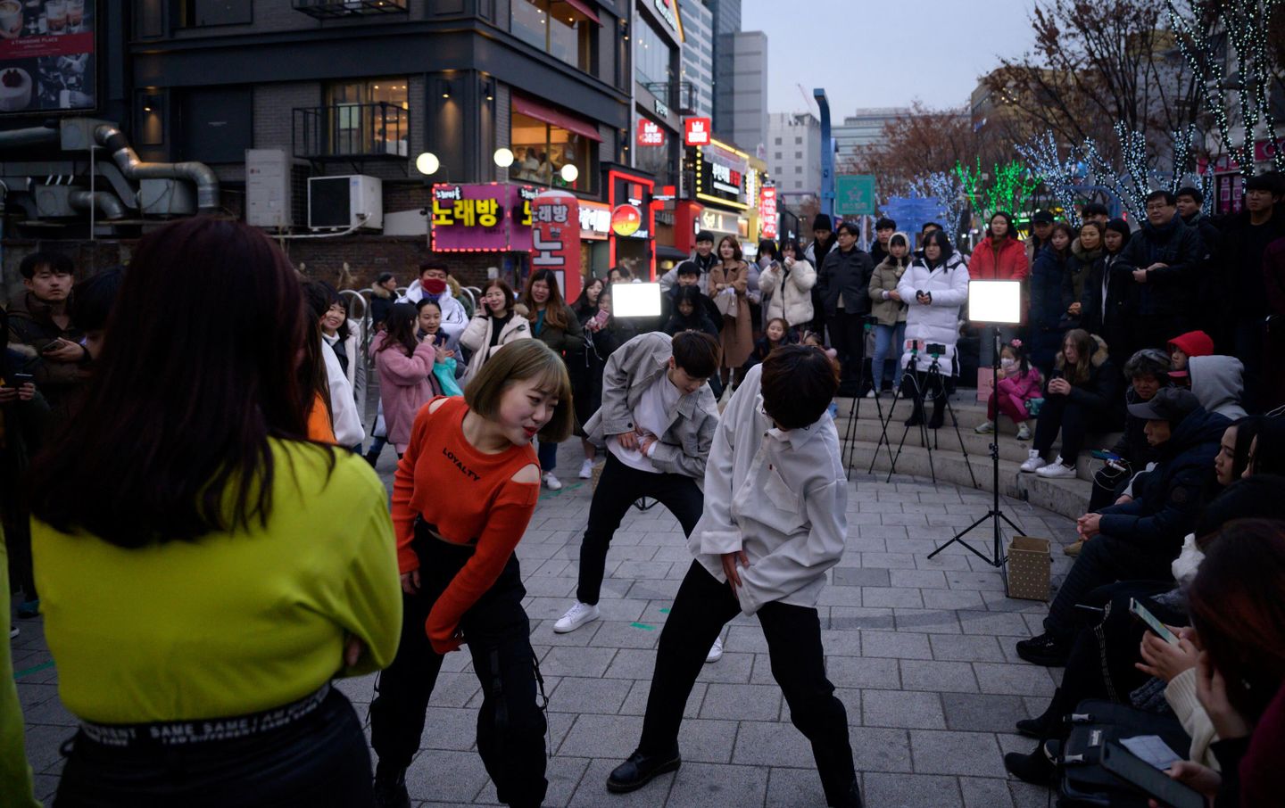 Любительская K-pop группа, выступающая на улице в районе Хондэ в Сеуле Любительская K-pop группа, выступающая на улице в районе Хондэ в Сеуле