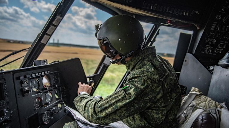 Военный летчик в кабине вертолета Ми-8МТВ на полевом аэродроме в зоне проведения специальной военной операции Военный летчик в кабине вертолета Ми-8МТВ на полевом аэродроме в зоне проведения специальной военной операции