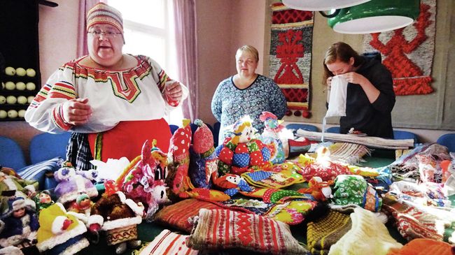 Продажа местных сувениров в Винницах. Туристка нюхает сушеные грибы Продажа местных сувениров в Винницах. Туристка нюхает сушеные грибы