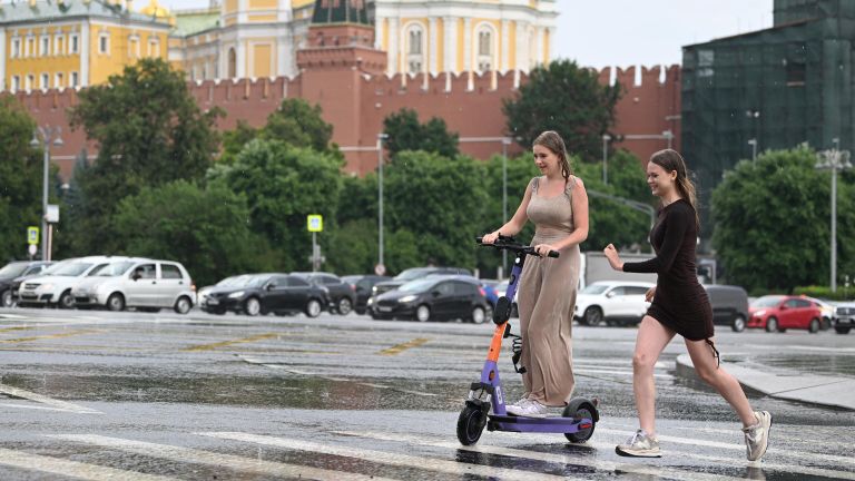 Девушки переходят улицу по лужам в Москве Девушки переходят улицу по лужам в Москве