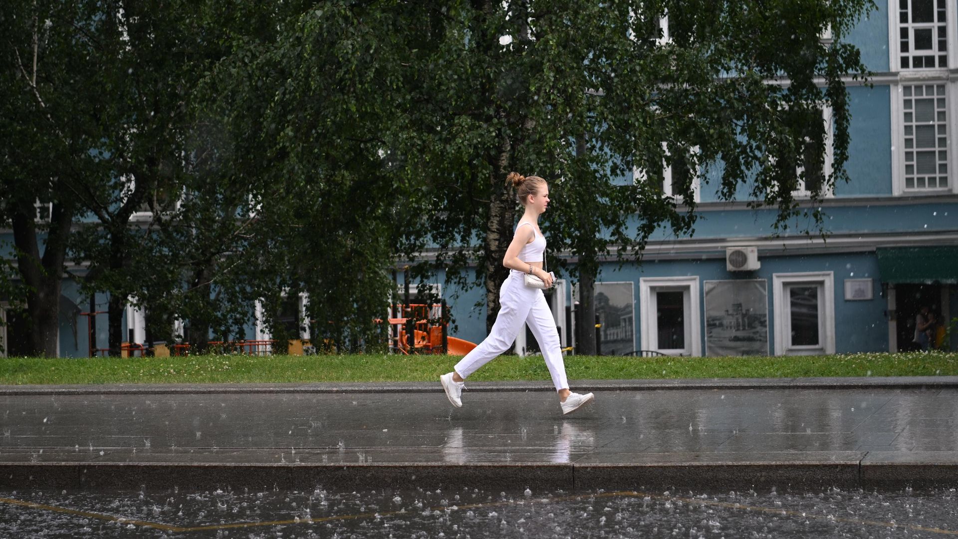 Женщина переходит улицу по лужам в Москве Женщина переходит улицу по лужам в Москве - РИА Новости, 1920, 07.08.2022