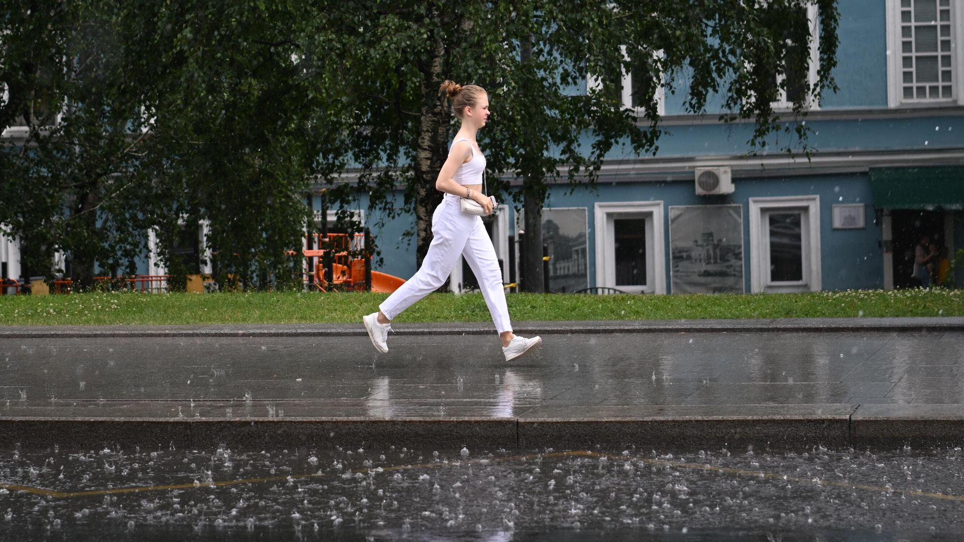 Женщина переходит улицу по лужам в Москве Женщина переходит улицу по лужам в Москве - РИА Новости, 1920, 07.08.2022
