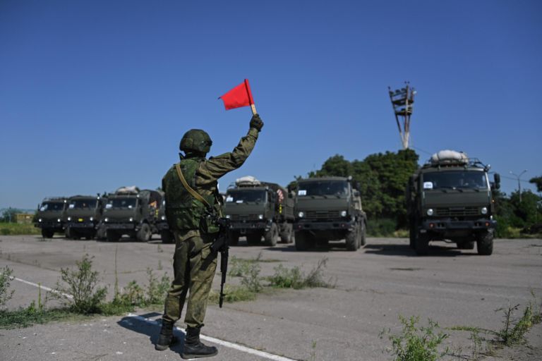 Военнослужащий подает сигналы флажком для проезда военной техники на территории аэропорта Мариуполя Военнослужащий подает сигналы флажком для проезда военной техники на территории аэропорта Мариуполя