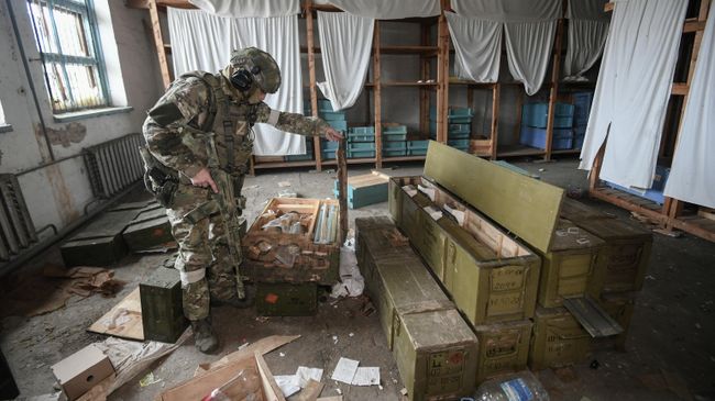 Военнослужащий ВС России осматривает боеприпасы, оставленные ВСУ в селе Александровка Херсонской области