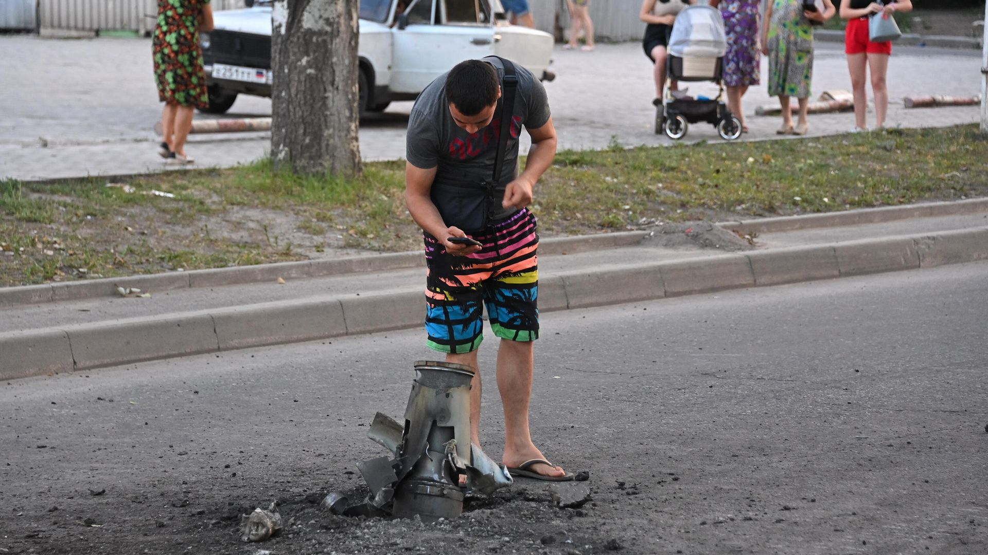 Жители города около неразорвавшегося боеприпаса на месте обстрела Ленинского района Донецка Жители города около неразорвавшегося боеприпаса на месте обстрела Ленинского района Донецка - РИА Новости, 1920, 18.08.2022