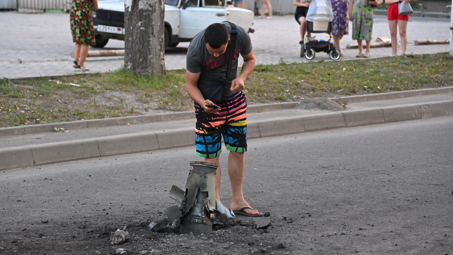Жители города около неразорвавшегося боеприпаса на месте обстрела Ленинского района Донецка - РИА Новости, 1920, 18.08.2022