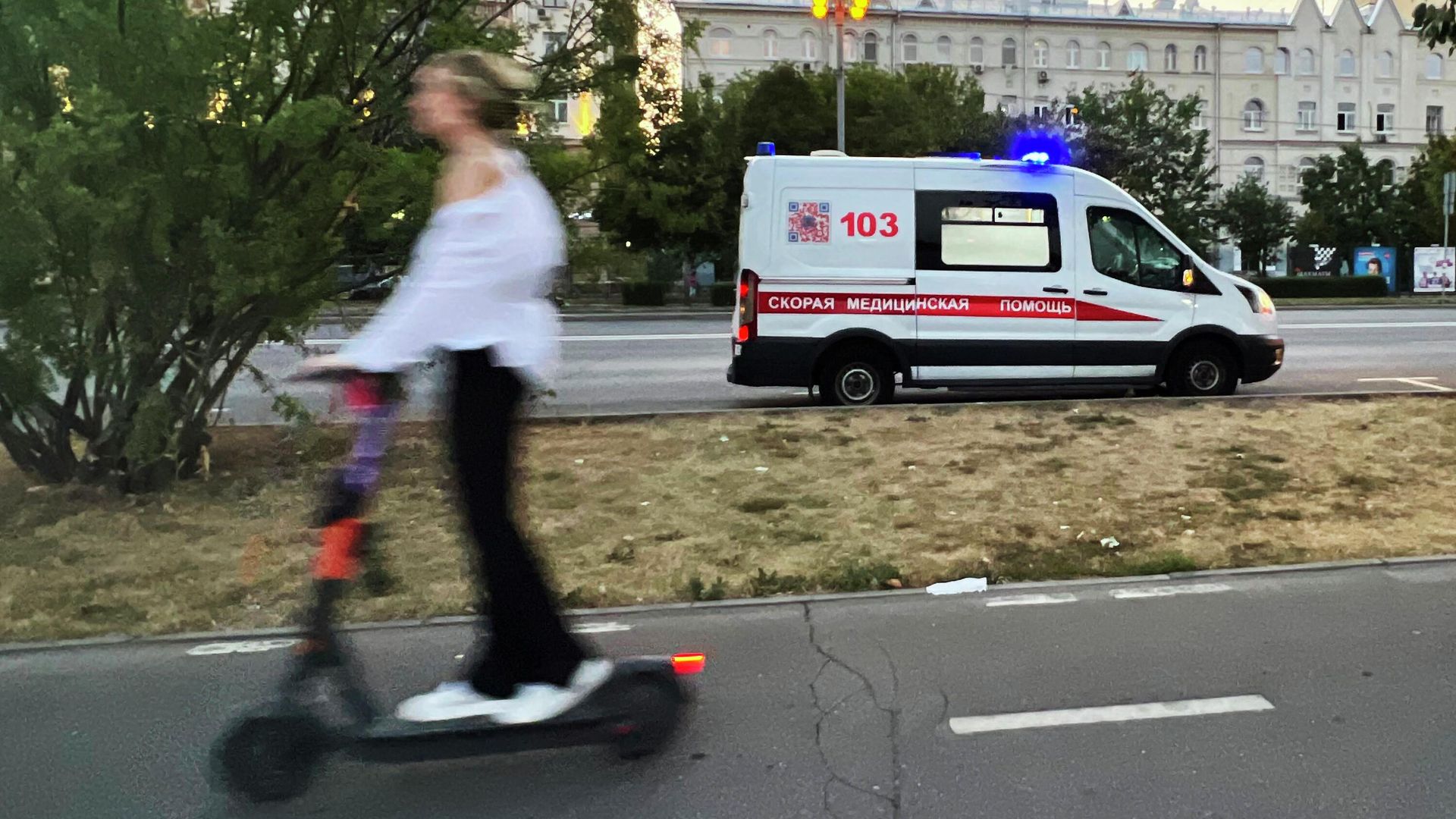 Девушка проезжает на самокате по тротуару недалеко от машины скорой помощи - РИА Новости, 1920, 03.07.2024