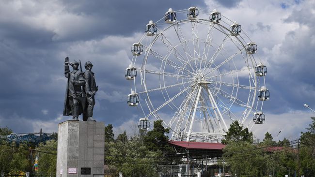 Памятник первым комсомольцам в Якутии. На заднем плане 40-метровое колесо обозрения в парке культуры и отдыха Якутска Памятник первым комсомольцам в Якутии. На заднем плане 40-метровое колесо обозрения в парке культуры и отдыха Якутска