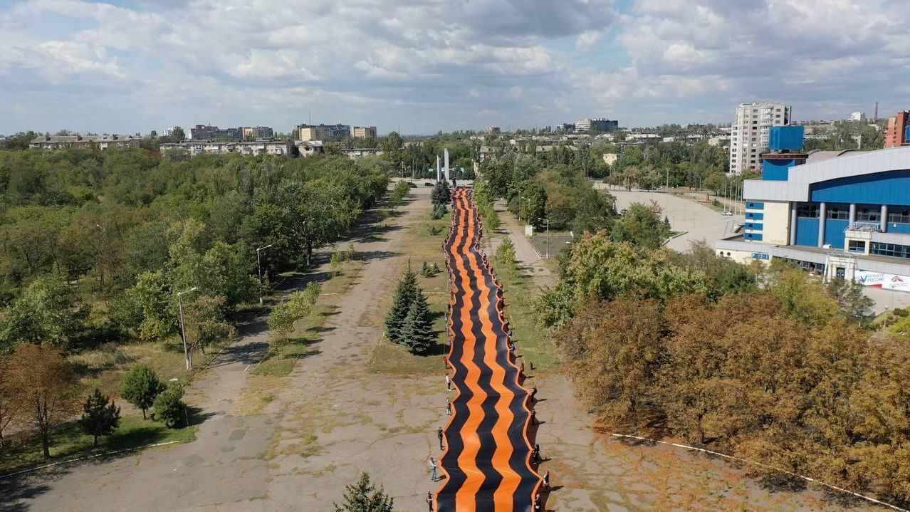 Активисты Молодой Гвардии Единой России и Волонтерской Роты развернули в Мариуполе самую большую в мире Георгиевскую ленту Активисты Молодой Гвардии Единой России и Волонтерской Роты развернули в Мариуполе самую большую в мире Георгиевскую ленту - РИА Новости, 1920, 10.09.2022