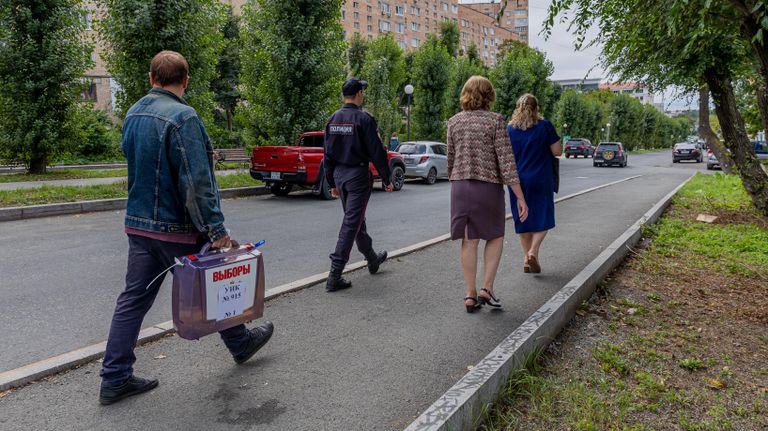 Члены избирательной комиссии и сотрудник полиции проводят выездное голосование на выборах депутатов городской Думы Владивостока Члены избирательной комиссии и сотрудник полиции проводят выездное голосование на выборах депутатов городской Думы Владивостока