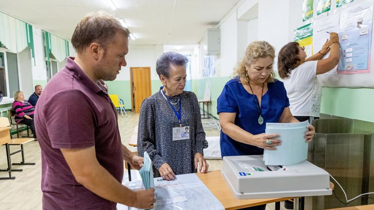 Сотрудники избирательной комиссии подсчитывают бюллетени после завершения голосования