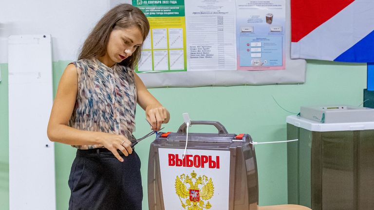 Сотрудница избирательной комиссии во Владивостоке вскрывает переносную урну для дальнейшего подсчета бюллетеней после завершения голосования Сотрудница избирательной комиссии во Владивостоке вскрывает переносную урну для дальнейшего подсчета бюллетеней после завершения голосования