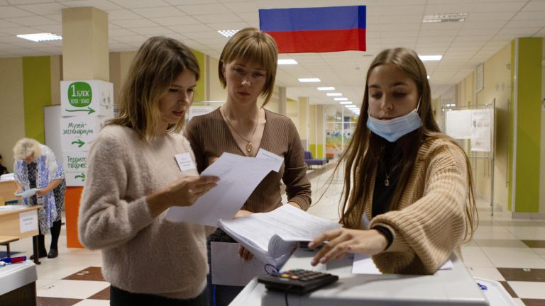 Сотрудники избирательного участка в Томске собирают данные по бюллетеням после завершения голосования на досрочных выборах губернатора области