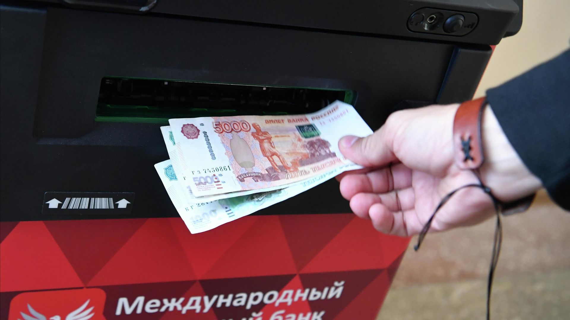 Человек снимает деньги в банкомате Человек снимает деньги в банкомате - РИА Новости, 1920, 23.03.2025