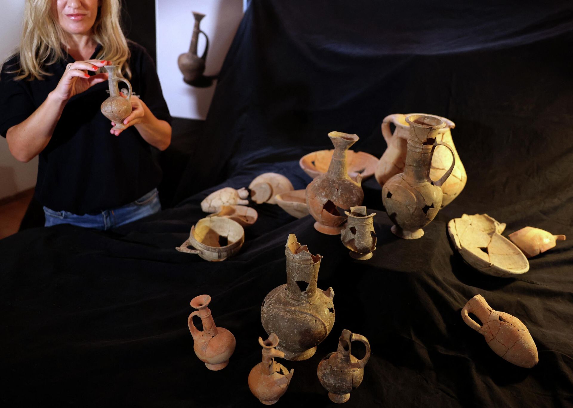 Сотрудник Управления древностей Израиля (IAA) держит один из сосудов, которые, как полагают, содержали опиум в XIV веке до н.э., найденный на месте захоронения Йехуд. 20 сентября 2022 года - РИА Новости, 1920, 23.09.2022