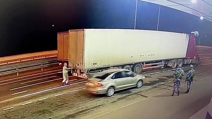 Сотрудник ДПС досматривает грузовой автомобиль на Крымском мосту Сотрудник ДПС досматривает грузовой автомобиль на Крымском мосту - РИА Новости, 1920, 12.10.2022