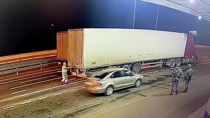 Сотрудник ДПС досматривает грузовой автомобиль на Крымском мосту Сотрудник ДПС досматривает грузовой автомобиль на Крымском мосту - РИА Новости, 1920, 12.10.2022
