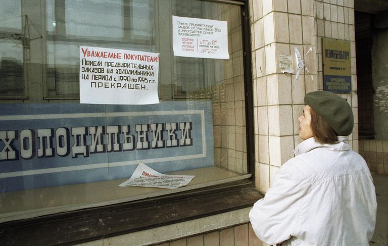 Женщина читает объявление в витрине магазина в Ленинграде бытовой техники об отсутствии в продаже холодильников во время дефицита товаров в начале 90-х годов в СССР Женщина читает объявление в витрине магазина в Ленинграде бытовой техники об отсутствии в продаже холодильников во время дефицита товаров в начале 90-х годов в СССР