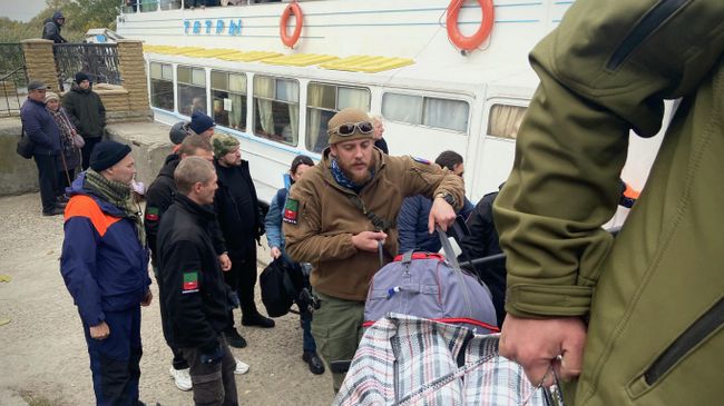 Волонтеры помогают донести вещи до автобуса