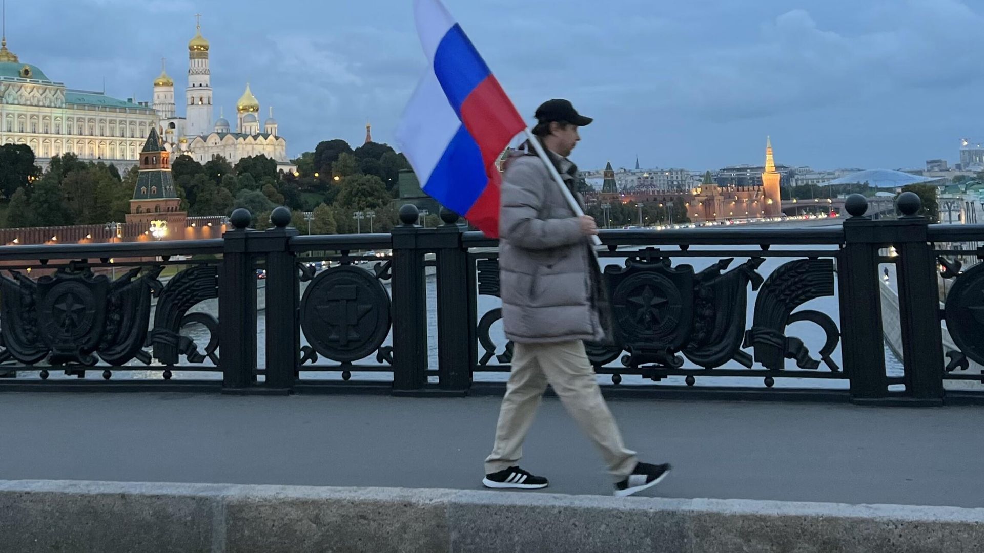 Мужчина с флагом России идет по Большому Каменному мосту после окончания митинга Своих не бросаем на Манежной площади в Москве. - РИА Новости, 1920, 28.10.2022
