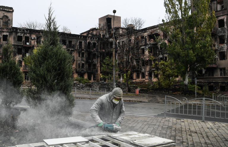 Рабочий во время работ по восстановлению жилого дома на одной из улиц в Мариуполе 