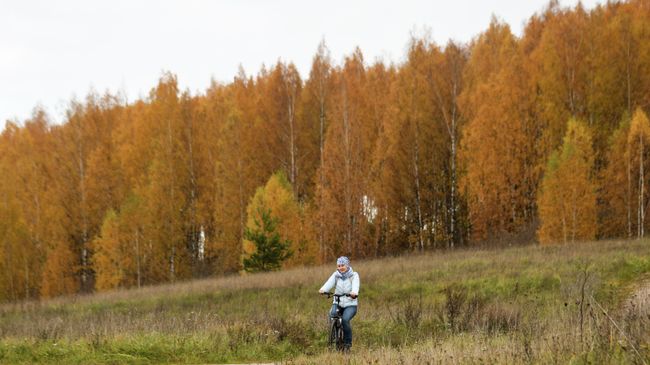 Женщина катается на велосипеде в окрестностях Изборско-Мальской долины