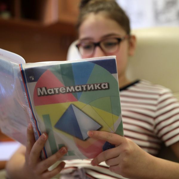 Школьница учит таблицу умножения по учебнику Школьница учит таблицу умножения по учебнику