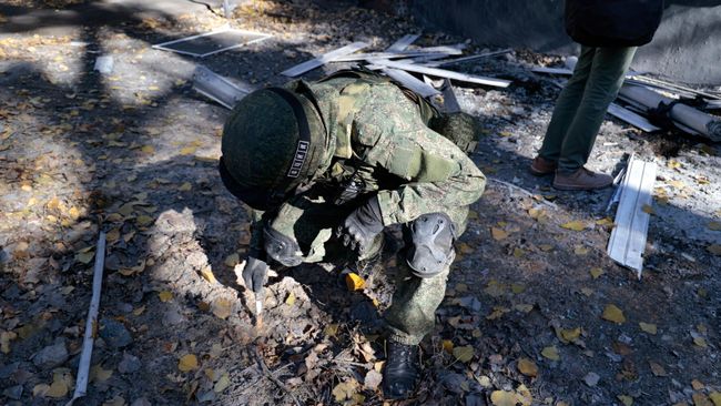 Сотрудник СЦКК ДНР возле жилого дома, пострадавшего при обстреле со стороны ВСУ Донецка