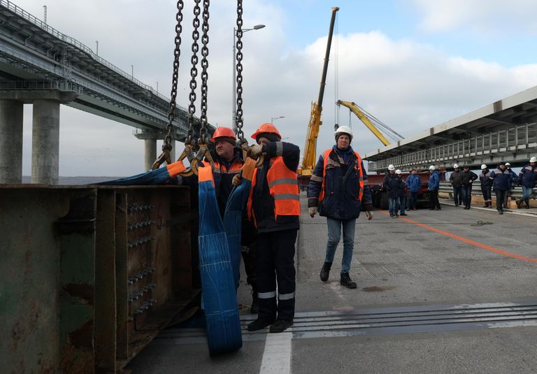 Строители во время первого этапа восстановления поврежденных пролетных строений автодорожной части мостового перехода Крымского моста Строители во время первого этапа восстановления поврежденных пролетных строений автодорожной части мостового перехода Крымского моста