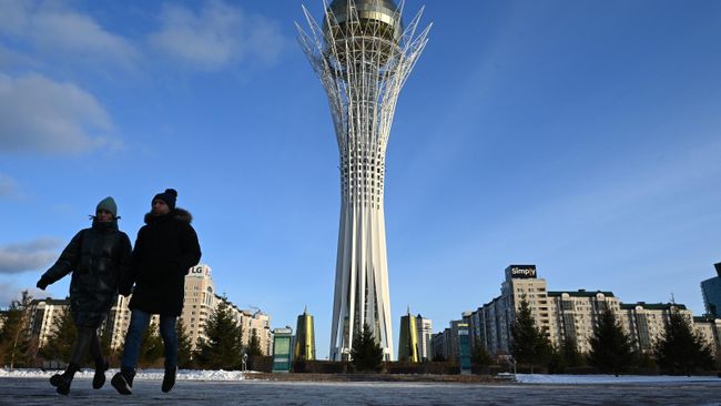 Люди гуляют у монумента на бульваре Нуржол в Астане Люди гуляют у монумента на бульваре Нуржол в Астане