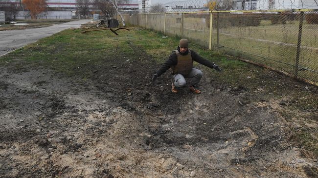 Сотрудник Росэнергоатома у воронки от разорвавшегося снаряда на территории Запорожской атомной электростанции после недавних обстрелов со стороны ВСУ