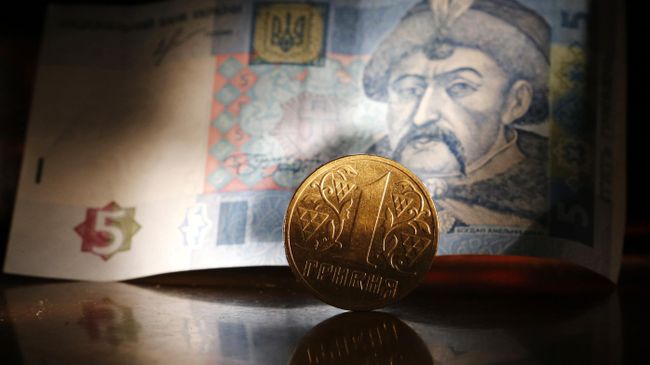 Денежные купюры и монета гривны