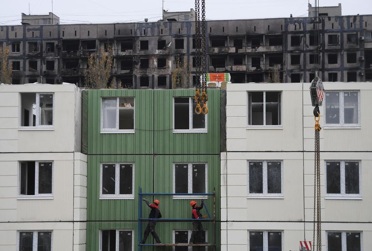 Рабочие во время строительства нового жилого дома на одной из улиц Мариуполя Рабочие во время строительства нового жилого дома на одной из улиц Мариуполя