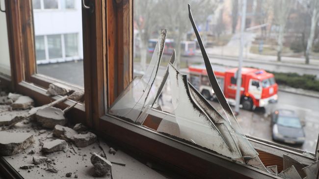 Разбитое окно в здании после попадания снаряда