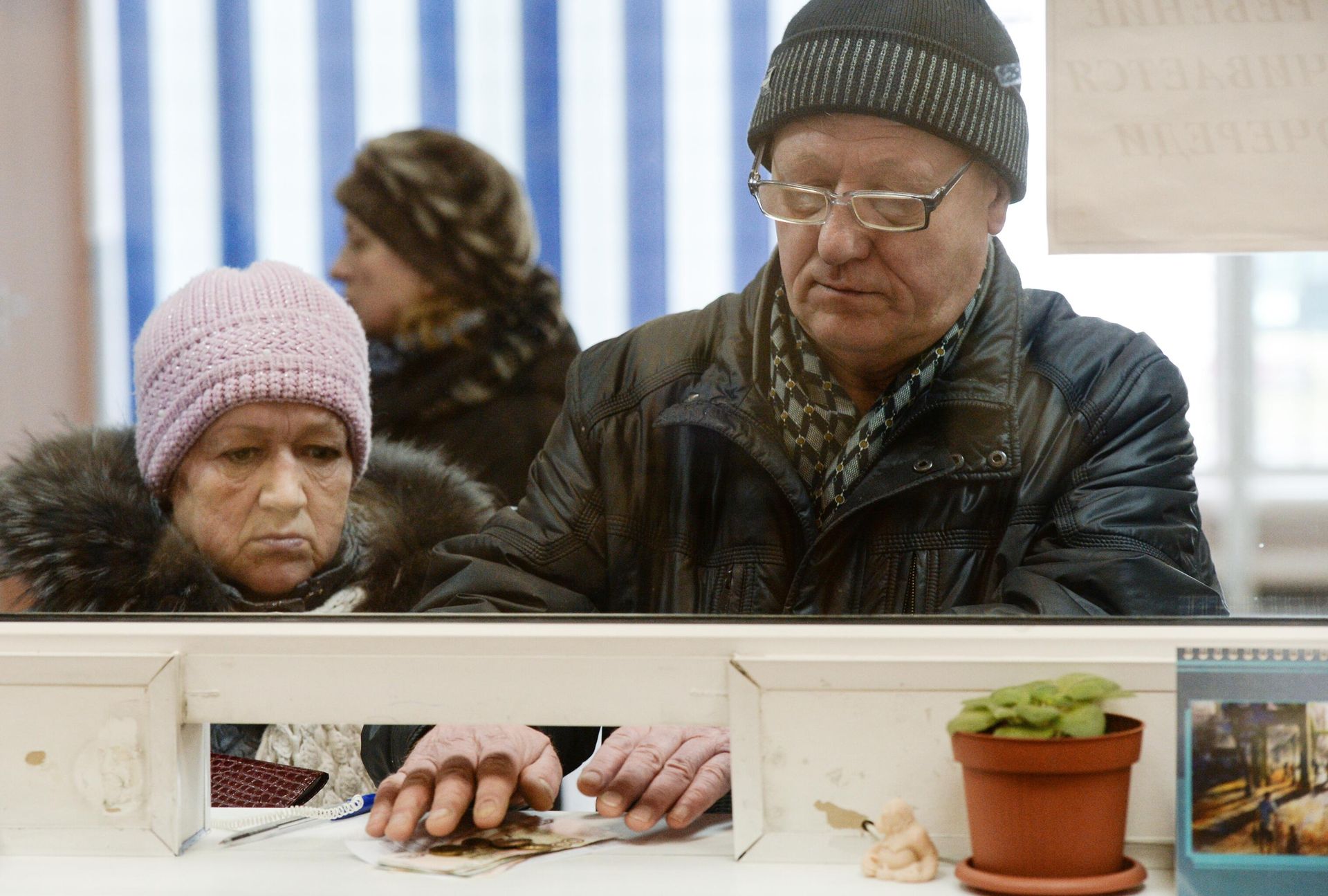 Пенсионер получает пенсию в одном из отделений Почты России Пенсионер получает пенсию в одном из отделений Почты России - РИА Новости, 1920, 23.12.2022