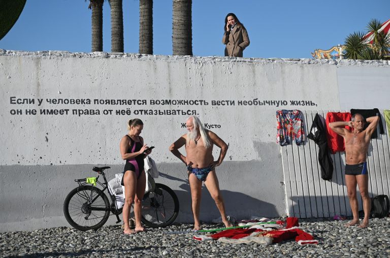 Отдыхающие на галечном пляже у Черного моря в Сочи Отдыхающие на галечном пляже у Черного моря в Сочи