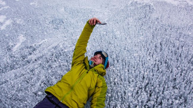 Девушка фотографируется на озере Байкал