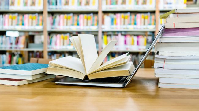 Открытая книга на ноутбуке Открытая книга на ноутбуке