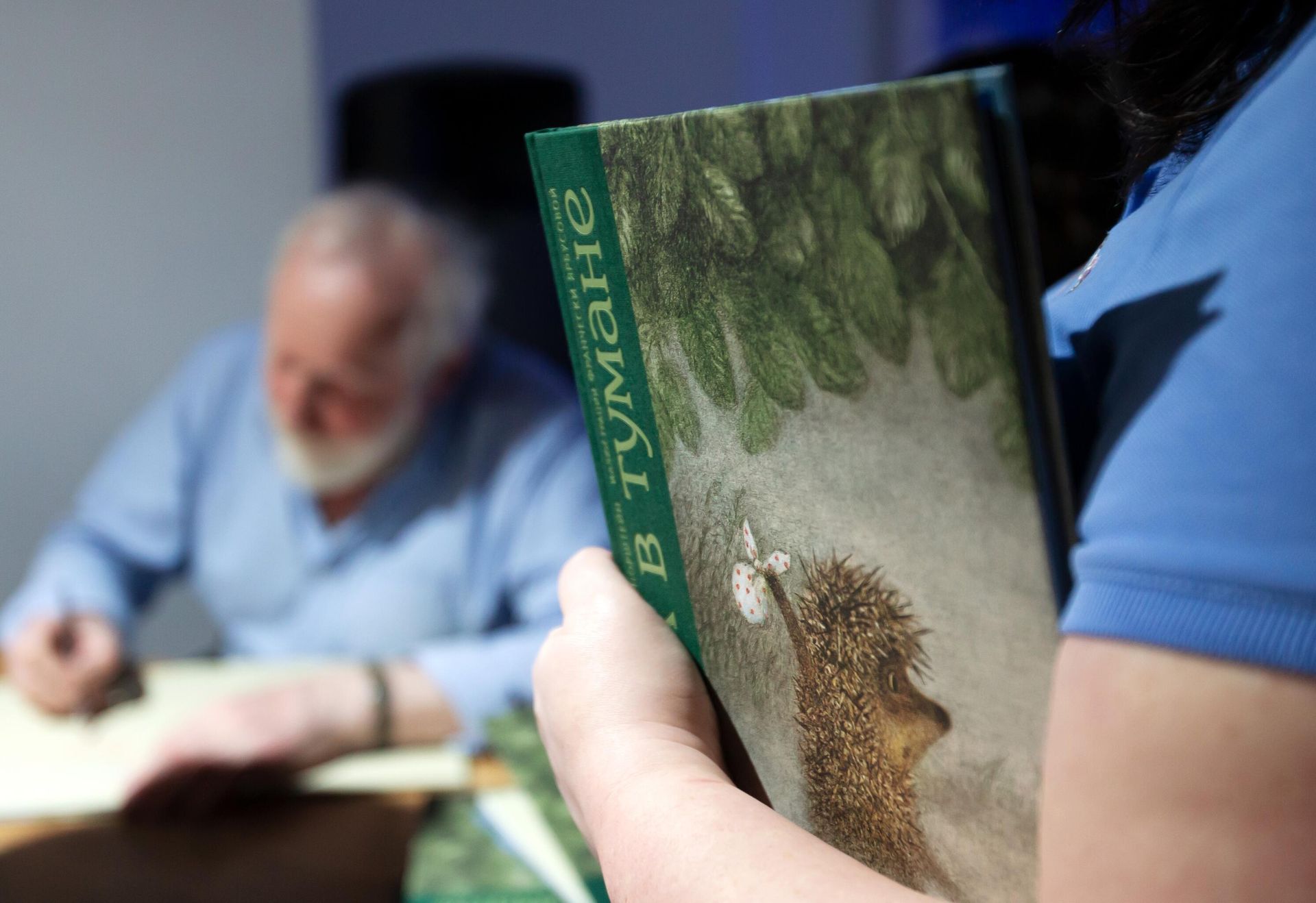 Девушка держит в руках книгу Ежик в тумане во время автограф-сессии после лекции режиссера мультипликационного кино и художника-мультипликатора Юрия Норштейна - РИА Новости, 1920, 15.09.2026